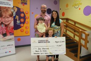 keira and her family holding a cheque
